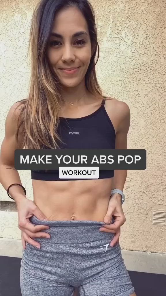 This may contain: a woman with her hands on her hips and the words make your abs pop workout