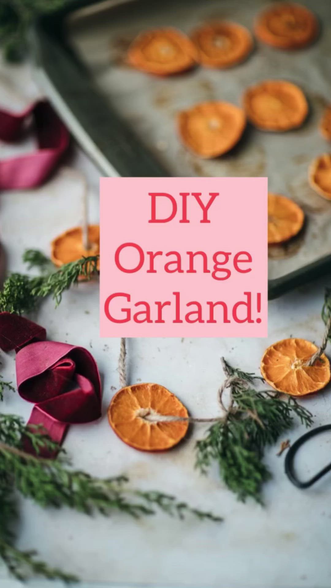 This may contain: an orange garland on a baking sheet with ribbon around it and some dried oranges in the background