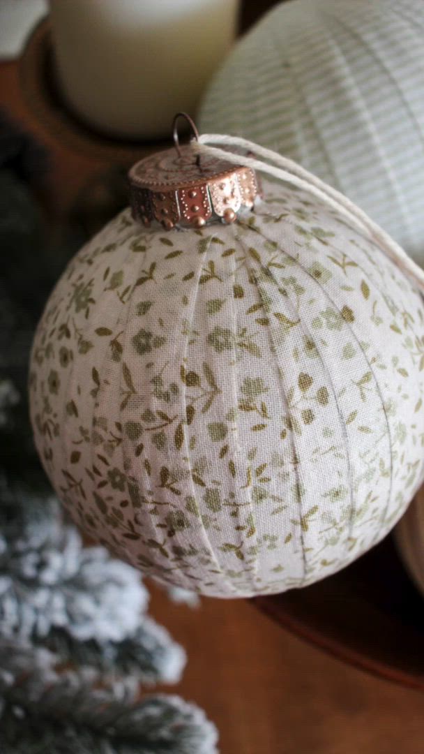 This may contain: a white ornament sitting on top of a wooden table next to a candle