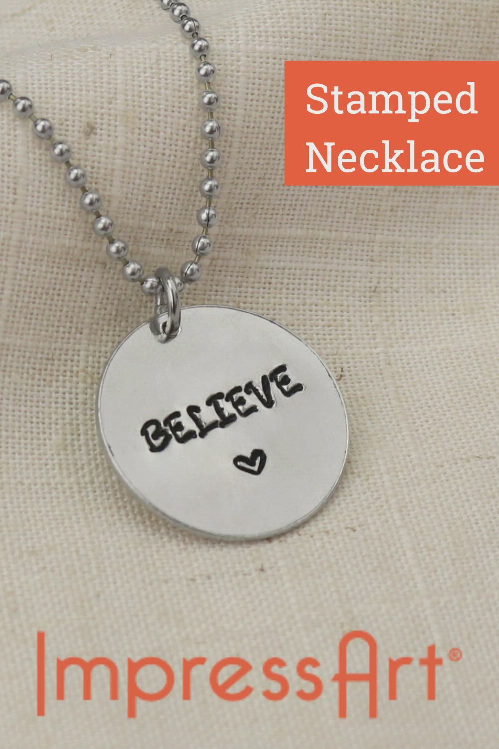 This may contain: a silver necklace with the words believe on it and an orange tag that says stamped necklace