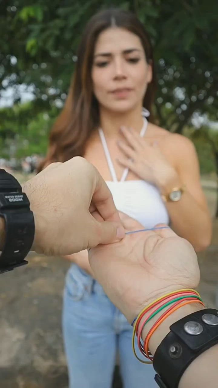 This may contain: a woman is holding the hand of a man with bracelets on his wrist while he looks at her watch