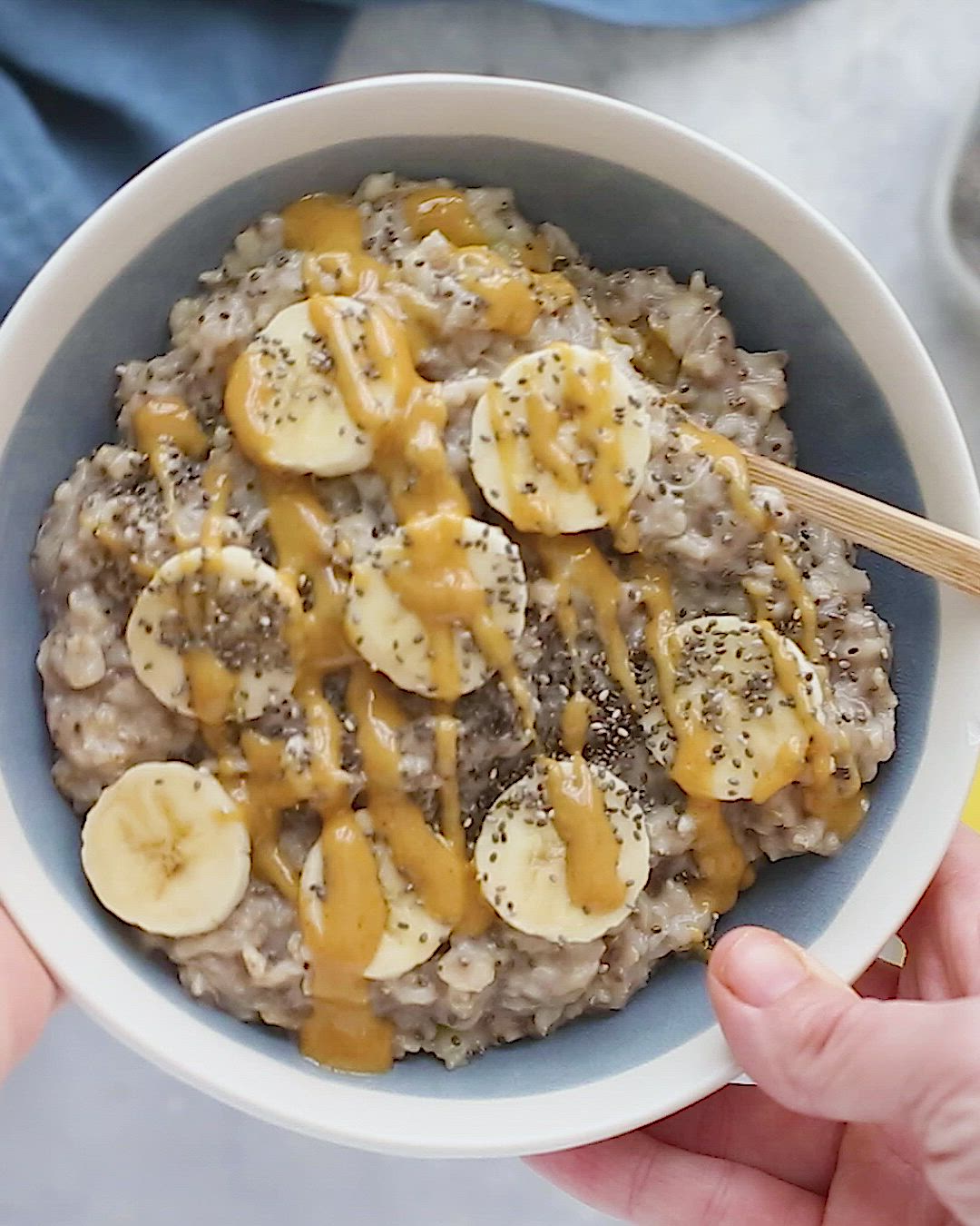 This may contain: a bowl filled with oatmeal topped with banana slices and caramel drizzle