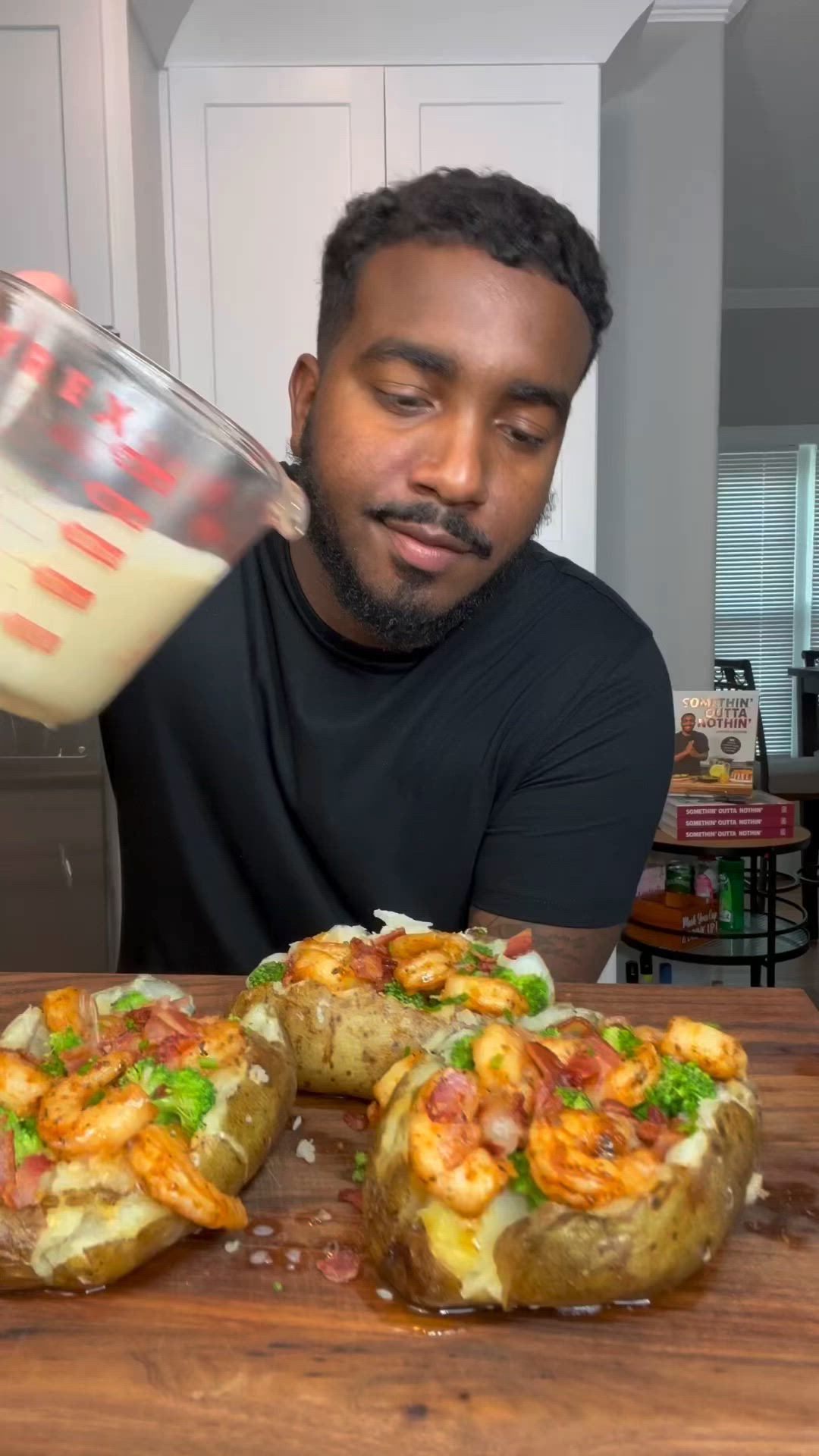 This may contain: a man is pouring milk over some food on a wooden table in front of him