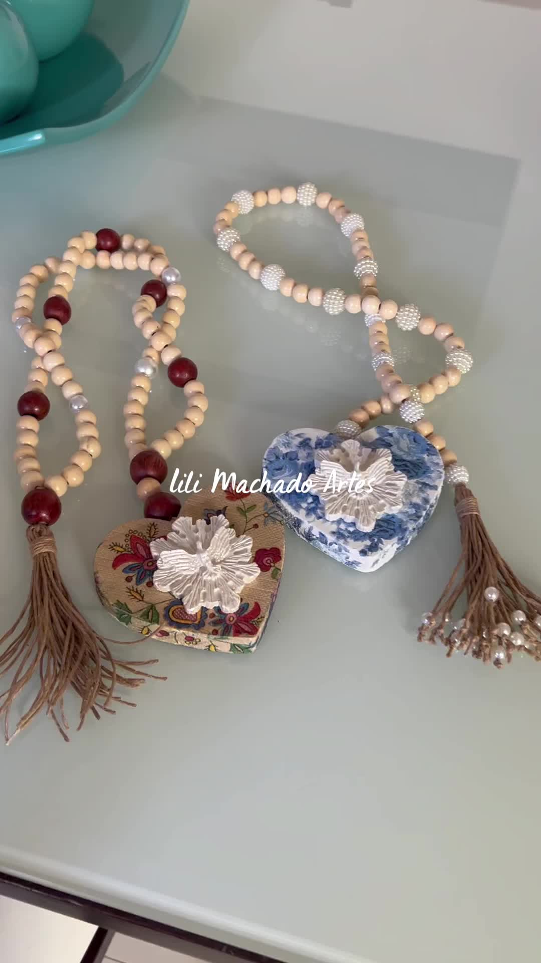 This may contain: two necklaces with beads and tassels on a table next to a bowl