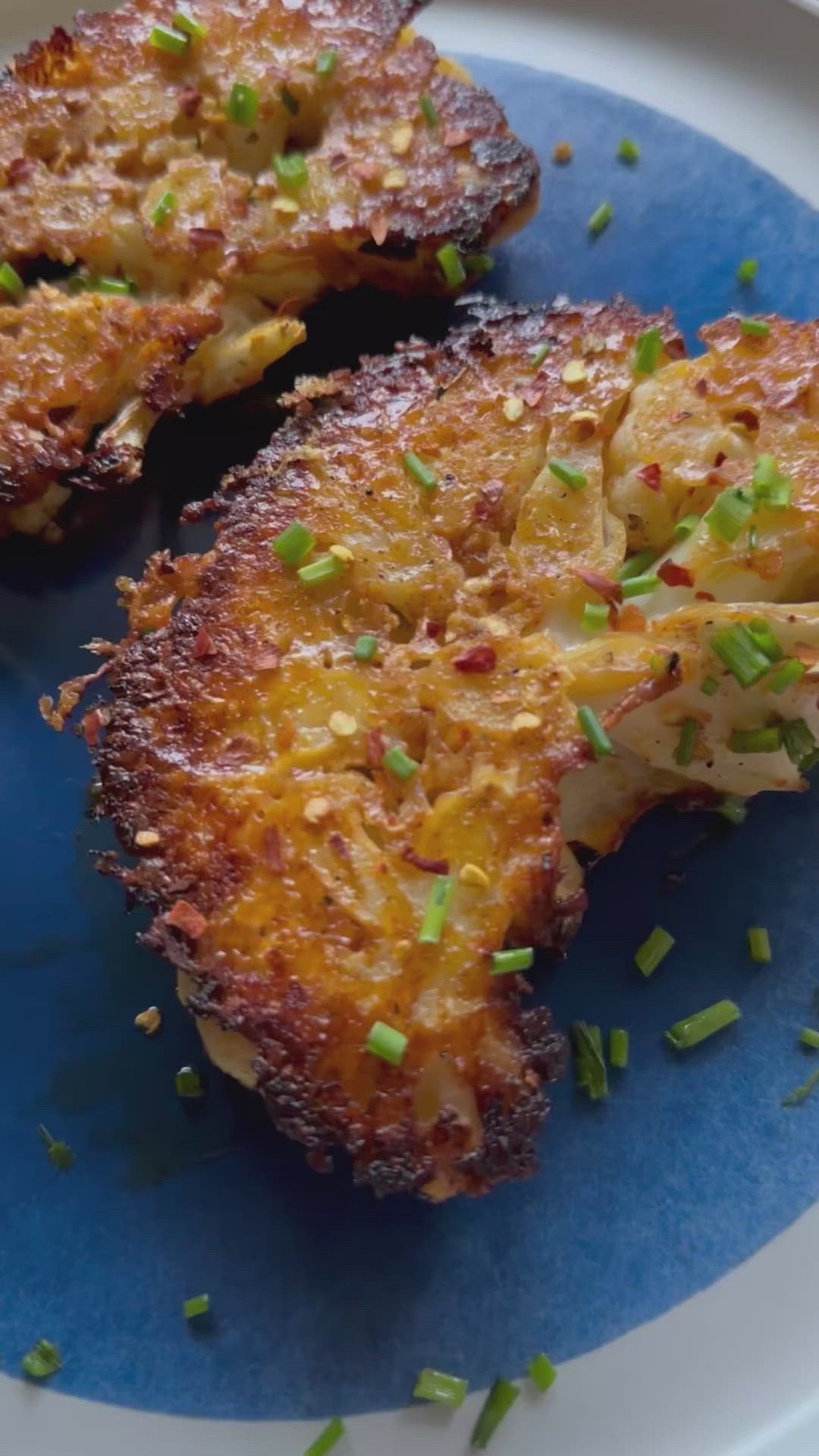 This may contain: two pieces of fried food on a blue and white plate with green sprinkles