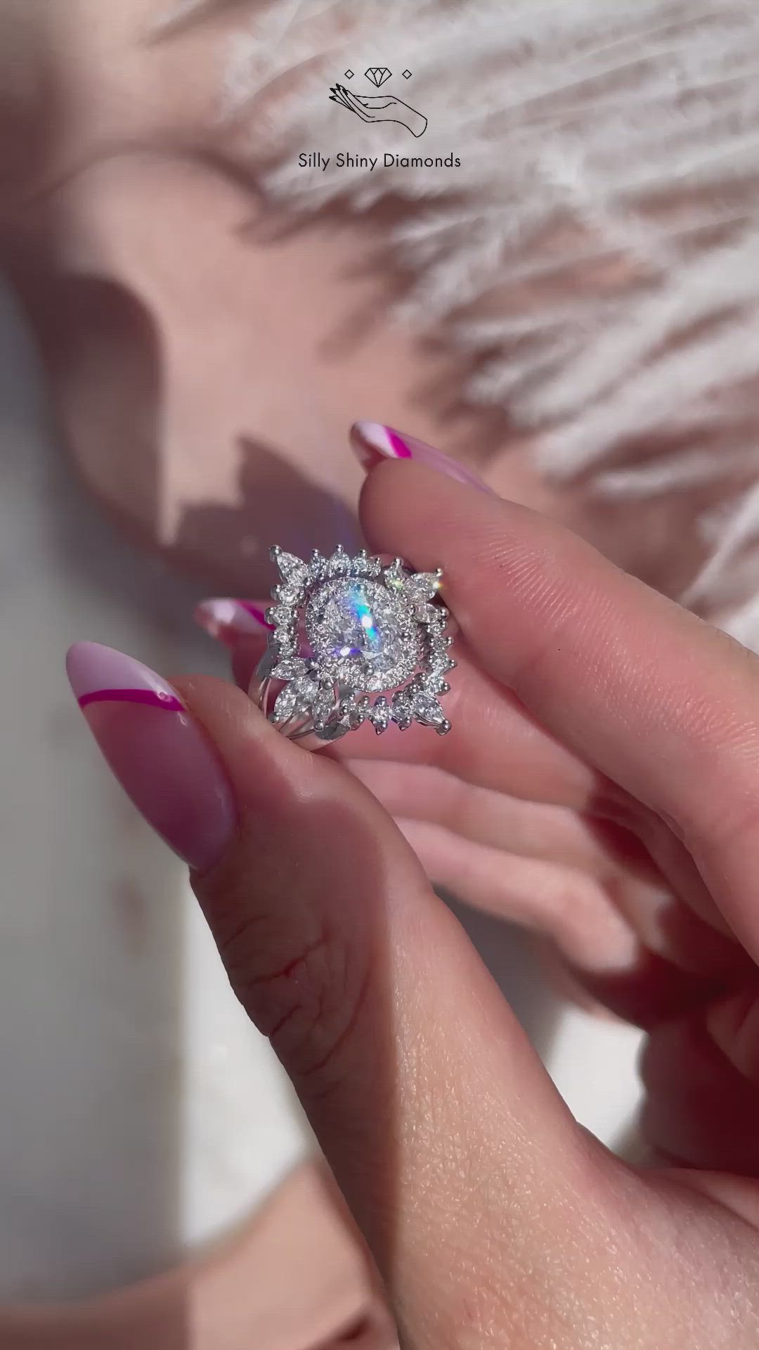 This may contain: a woman's hand holding an engagement ring with pink and white manicured nails