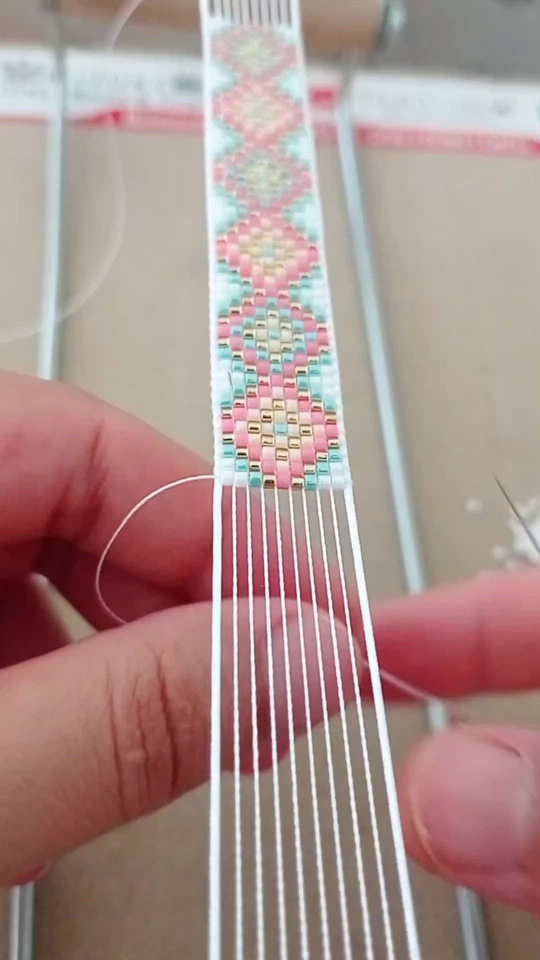 This may contain: someone is making a beaded bracelet out of white thread