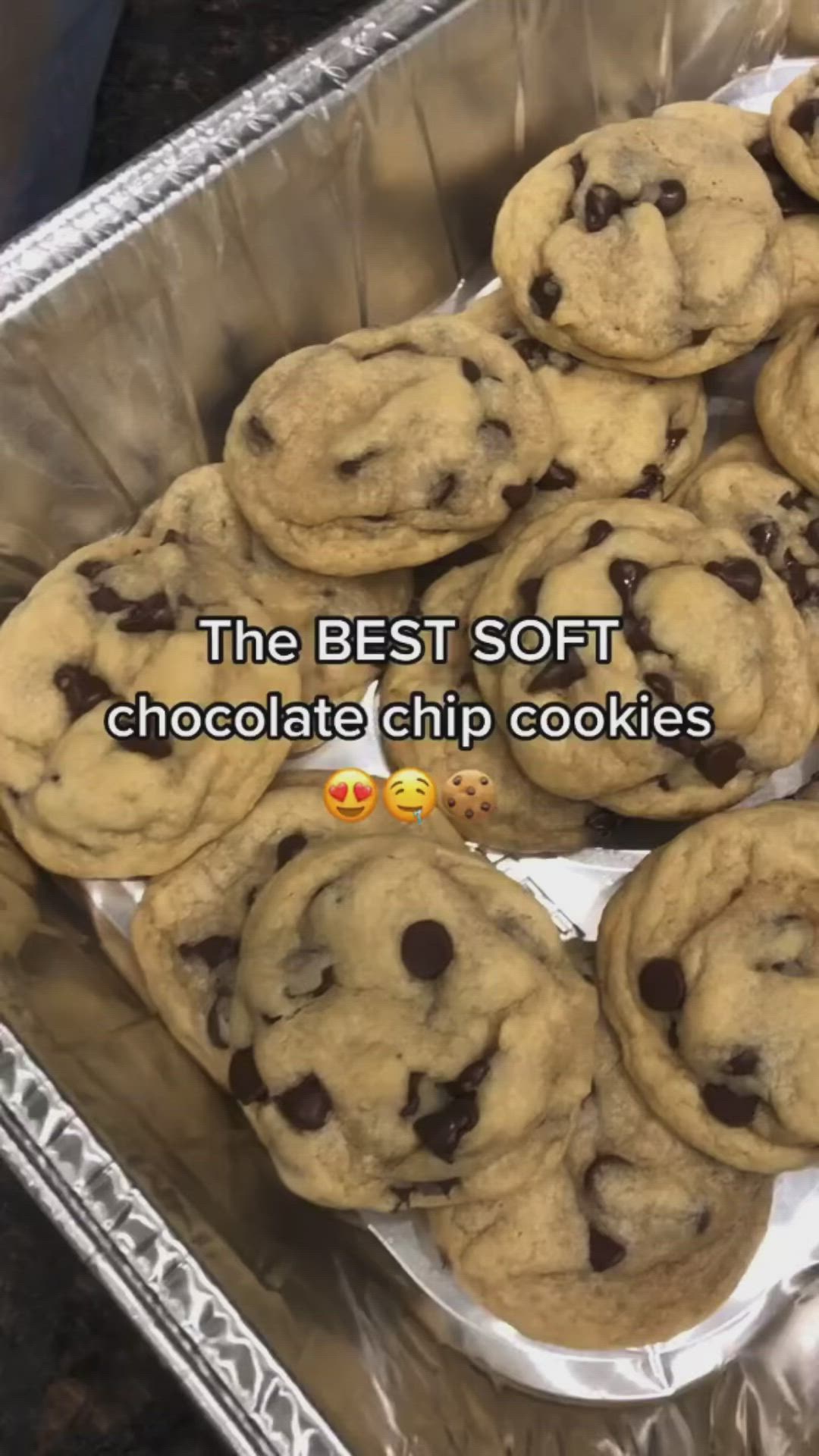 This may contain: the best soft chocolate chip cookies are on display in an aluminum baking pan with text overlay