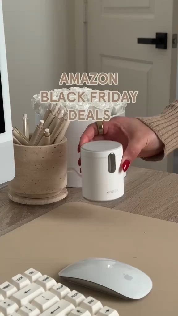 This may contain: a woman is holding a coffee mug near a computer keyboard and monitor with the words amazon black friday on it