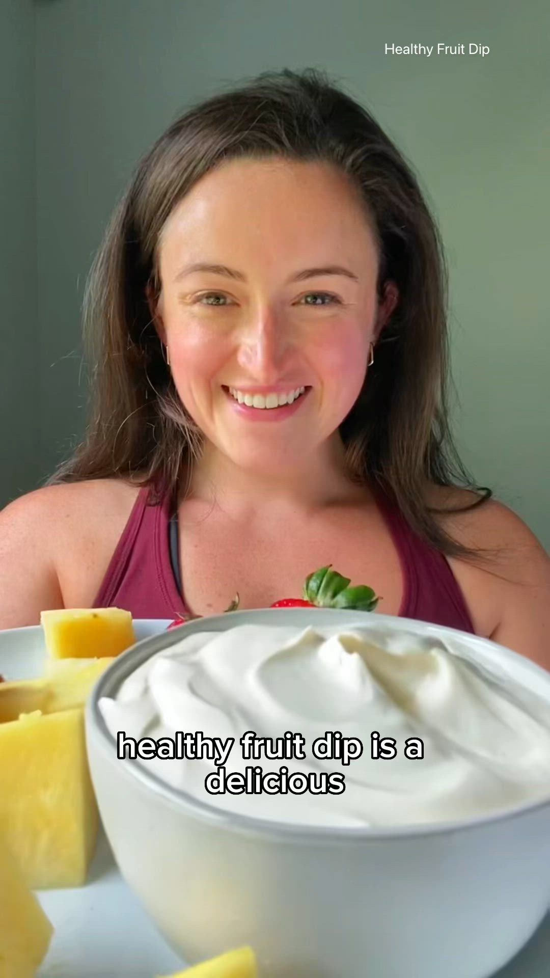 This may contain: a woman sitting in front of a plate of food with cheese and fruit on it