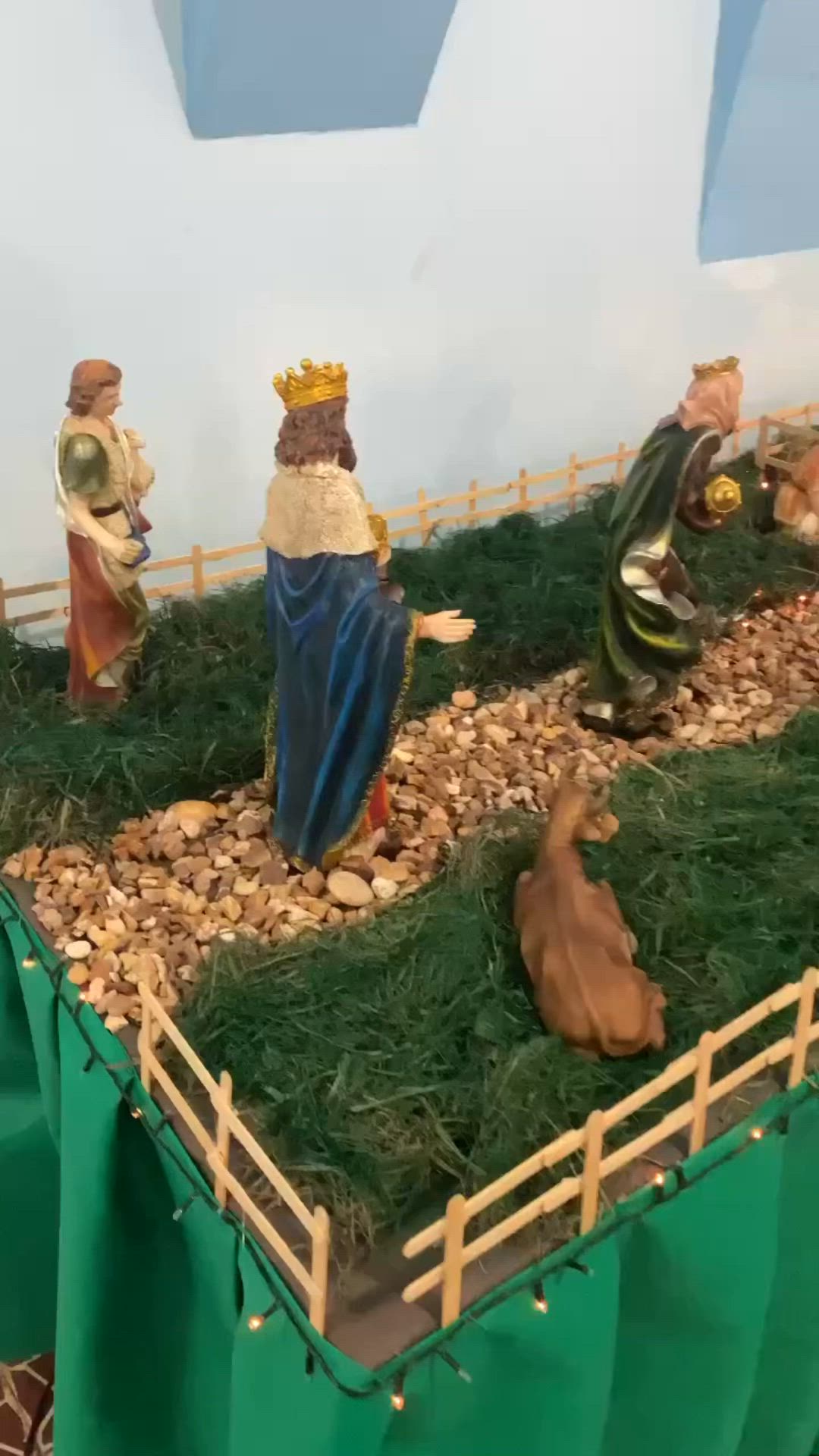 This may contain: the nativity scene is displayed in front of a blue wall