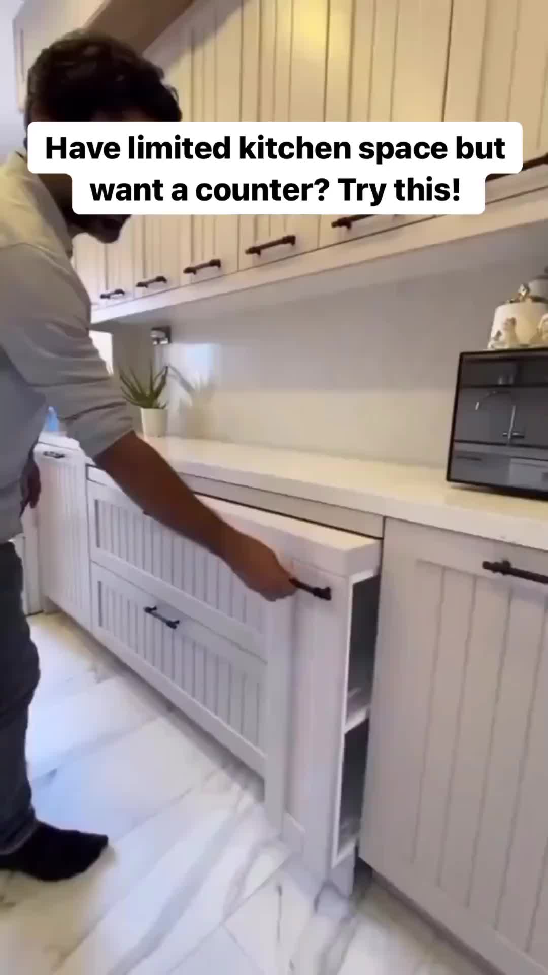 This may contain: a man standing in the middle of a kitchen with an open cabinet door that says have limited kitchen space but want a counter? try this