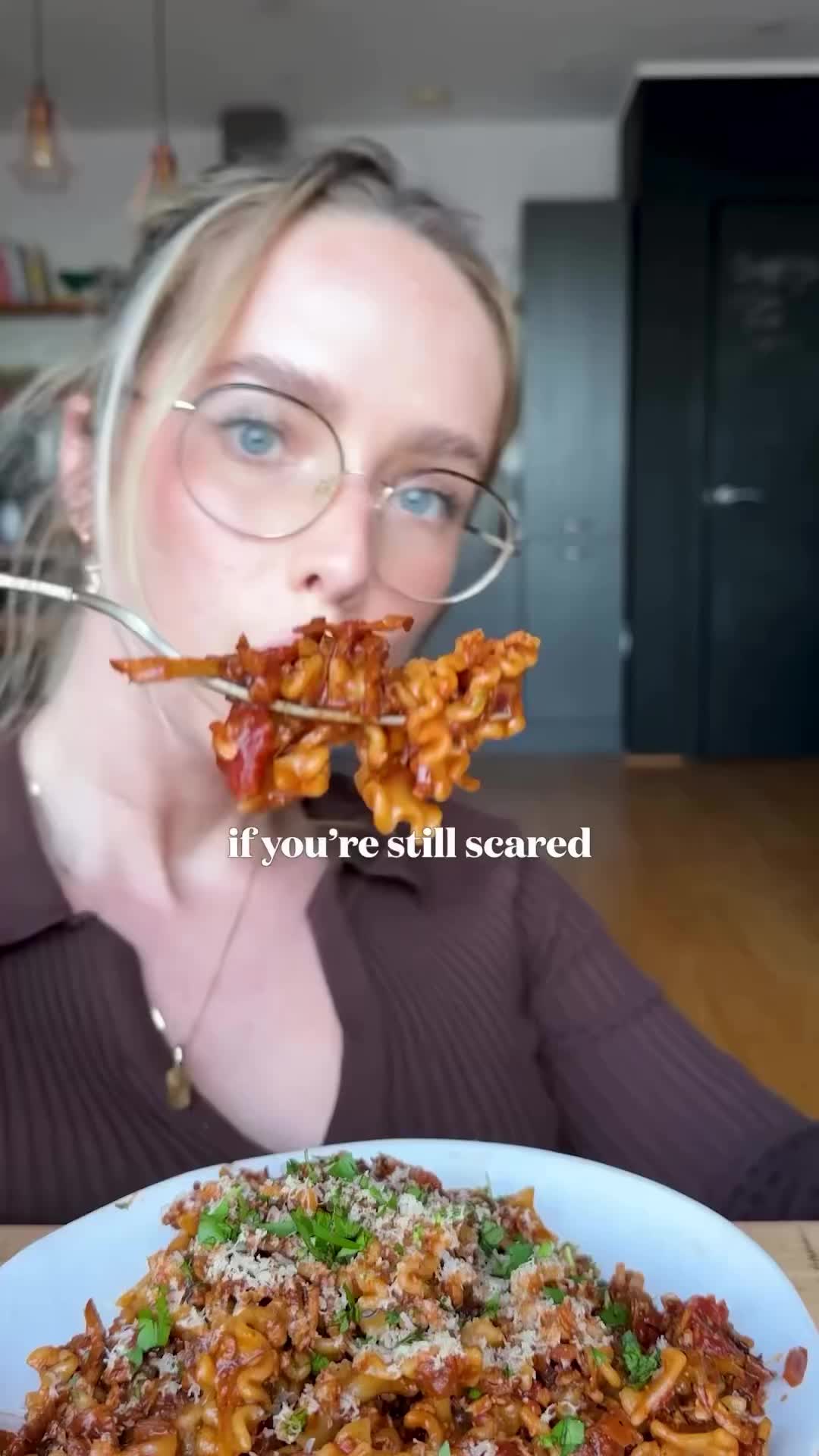 This may contain: a woman with glasses is holding up a plate of food in front of her face