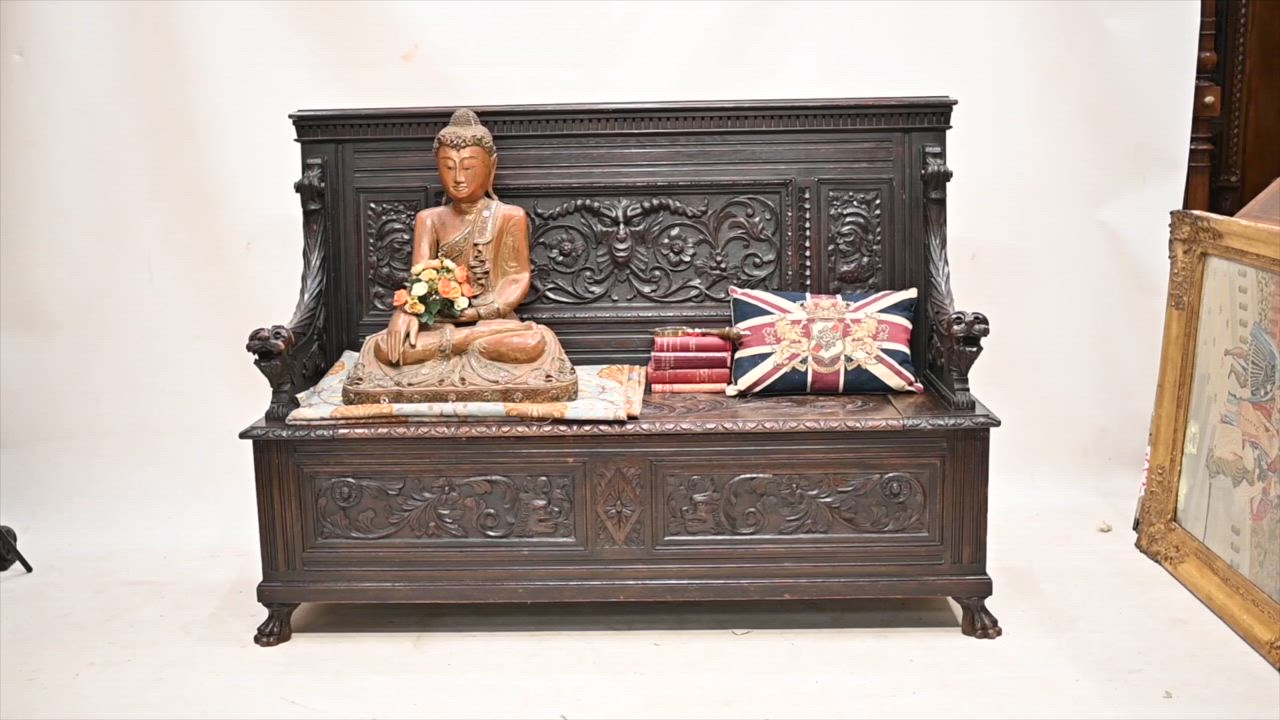 This may contain: a buddha statue sitting on top of a wooden bench next to a flag and flowers