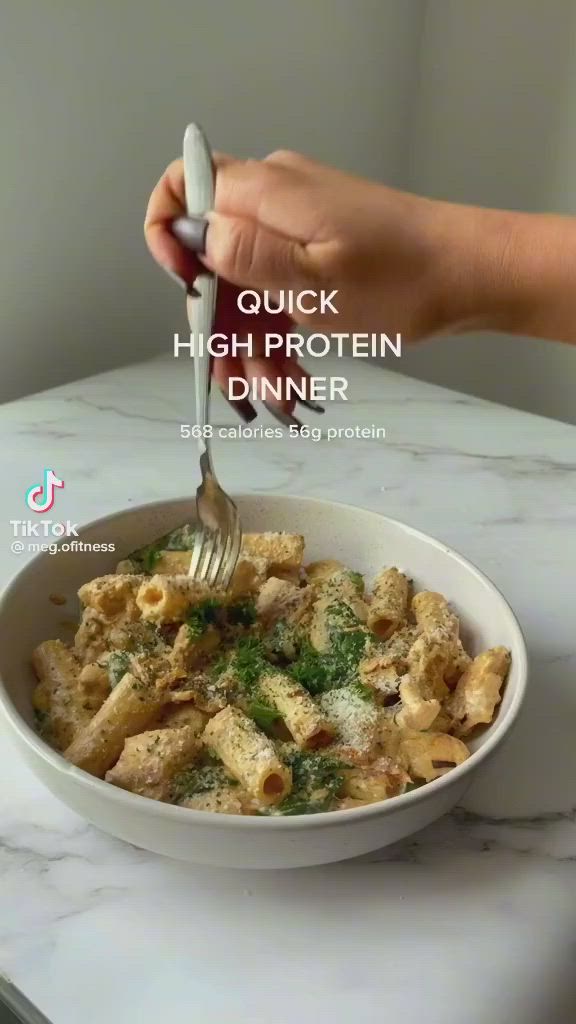 This may contain: a hand holding a fork over a bowl of food on a marble counter top with the words quick high protein dinner