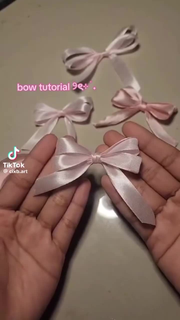 This may contain: two hands holding small bows on top of a white surface with the words bow tutorial se