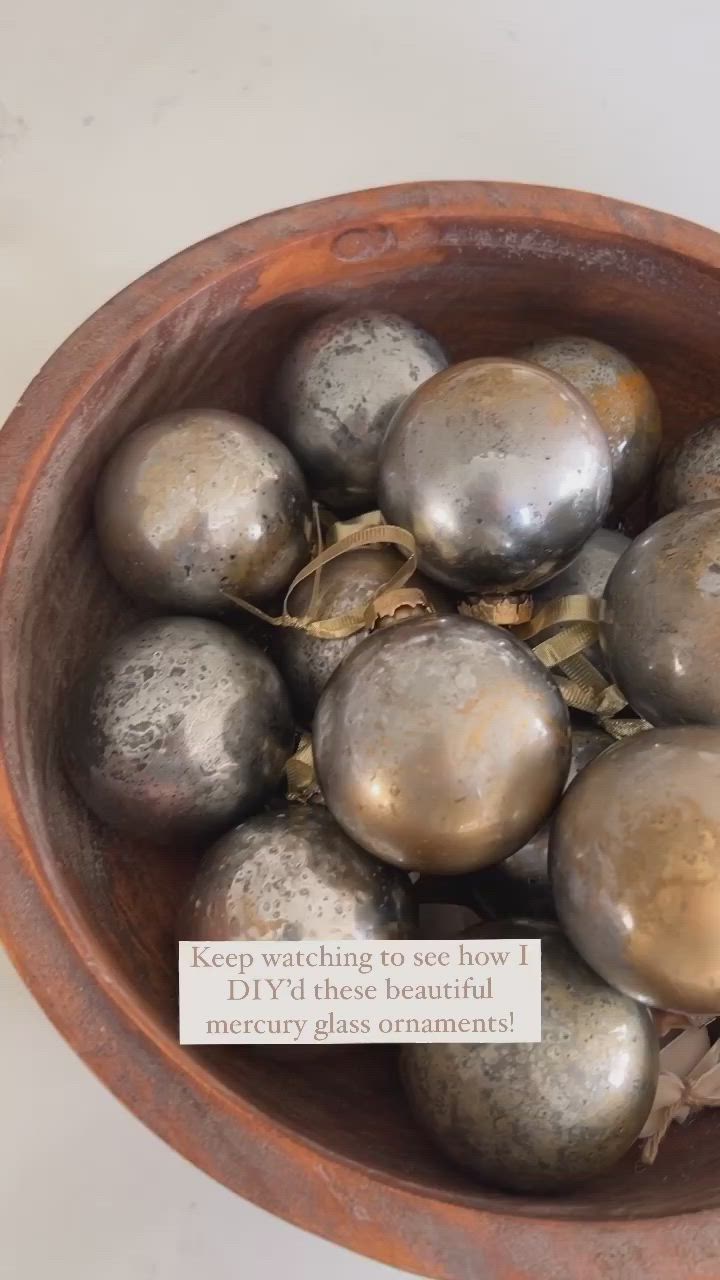 This may contain: a wooden bowl filled with metal balls on top of a table