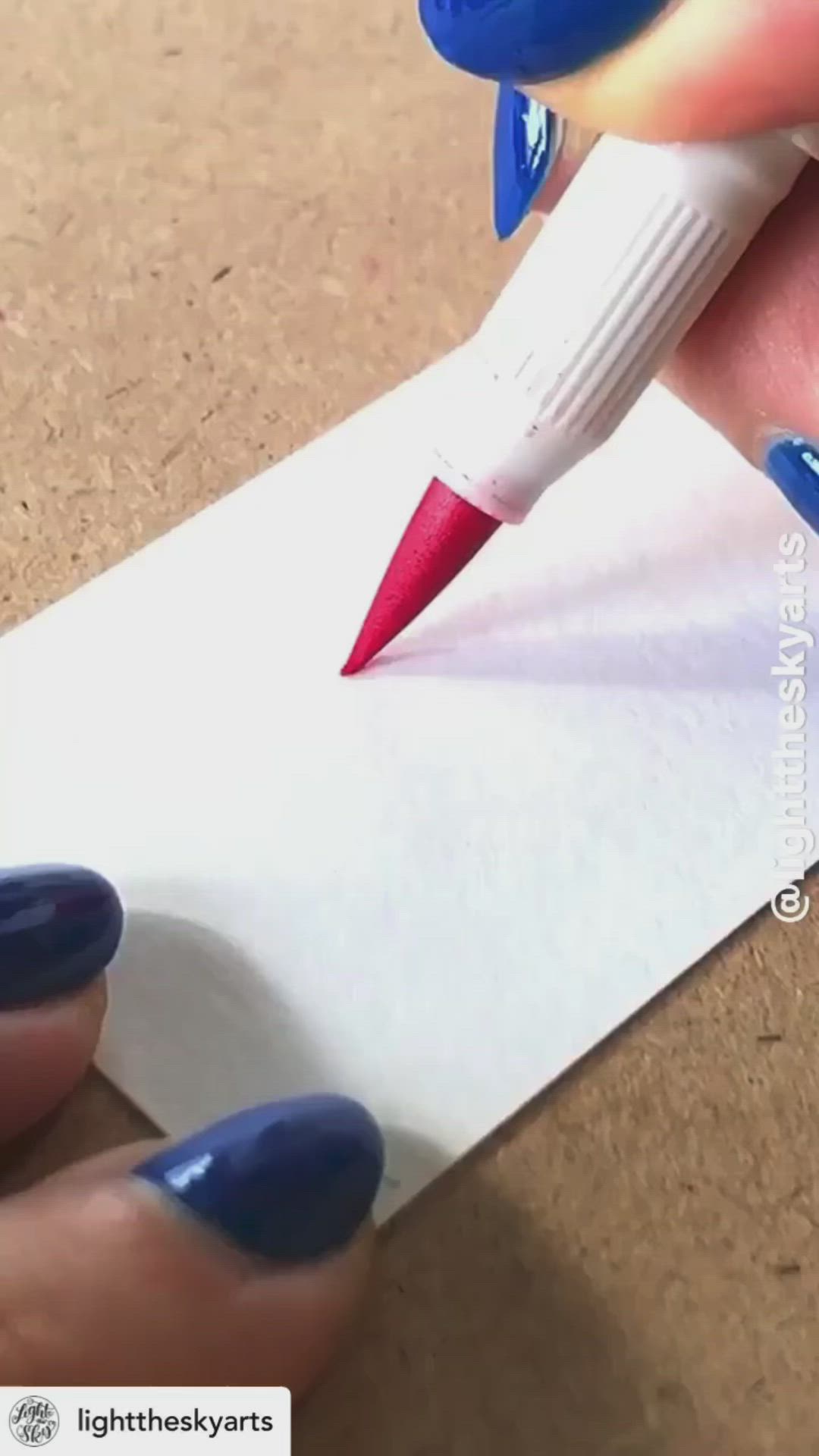 This may contain: a person is writing on a piece of paper with blue and red nail polishes