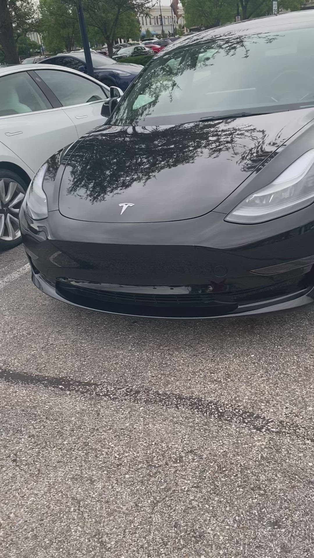 This may contain: a black sports car parked in a parking lot