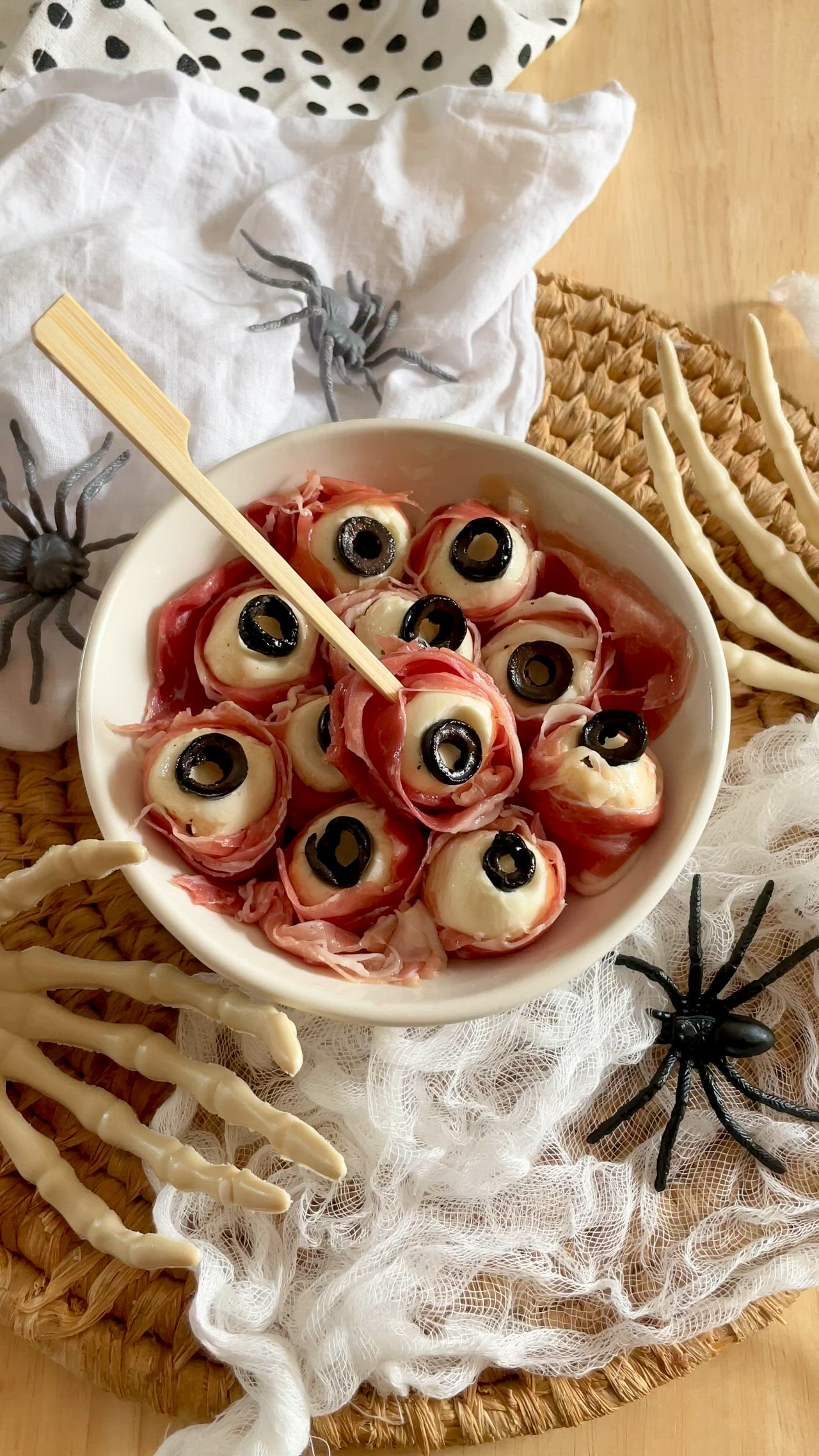 This may contain: a white bowl filled with food on top of a wooden table next to halloween decorations