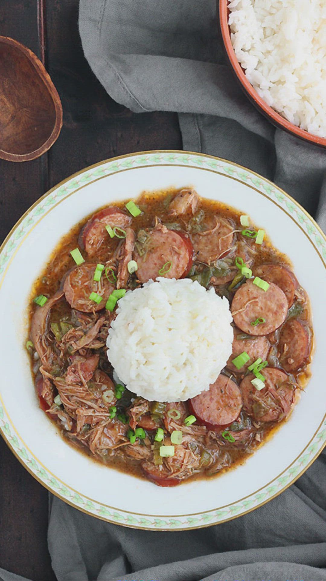 This contains: chicken and sausage gumbo in a white soup bowl