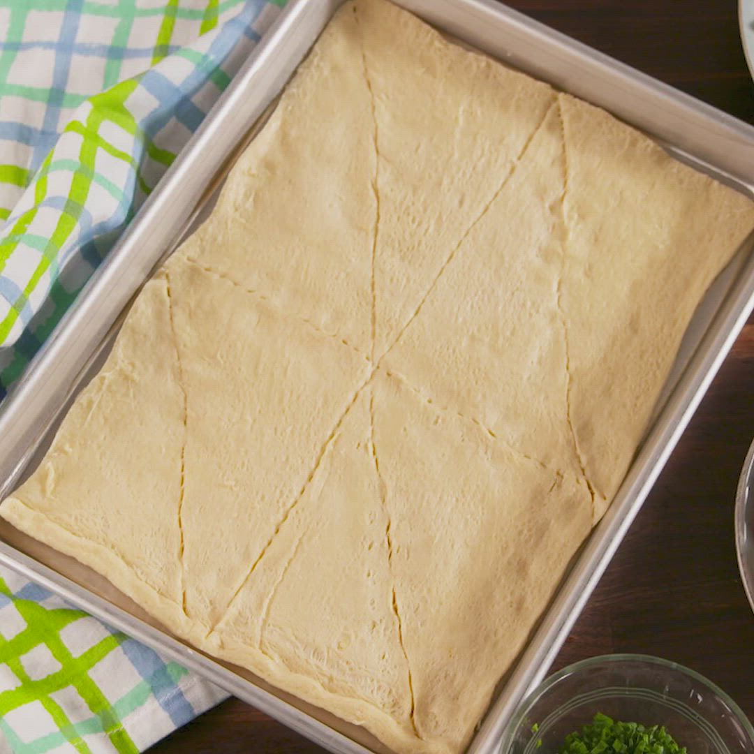 This may contain: an uncooked dough in a pan on a table with bowls and napkins