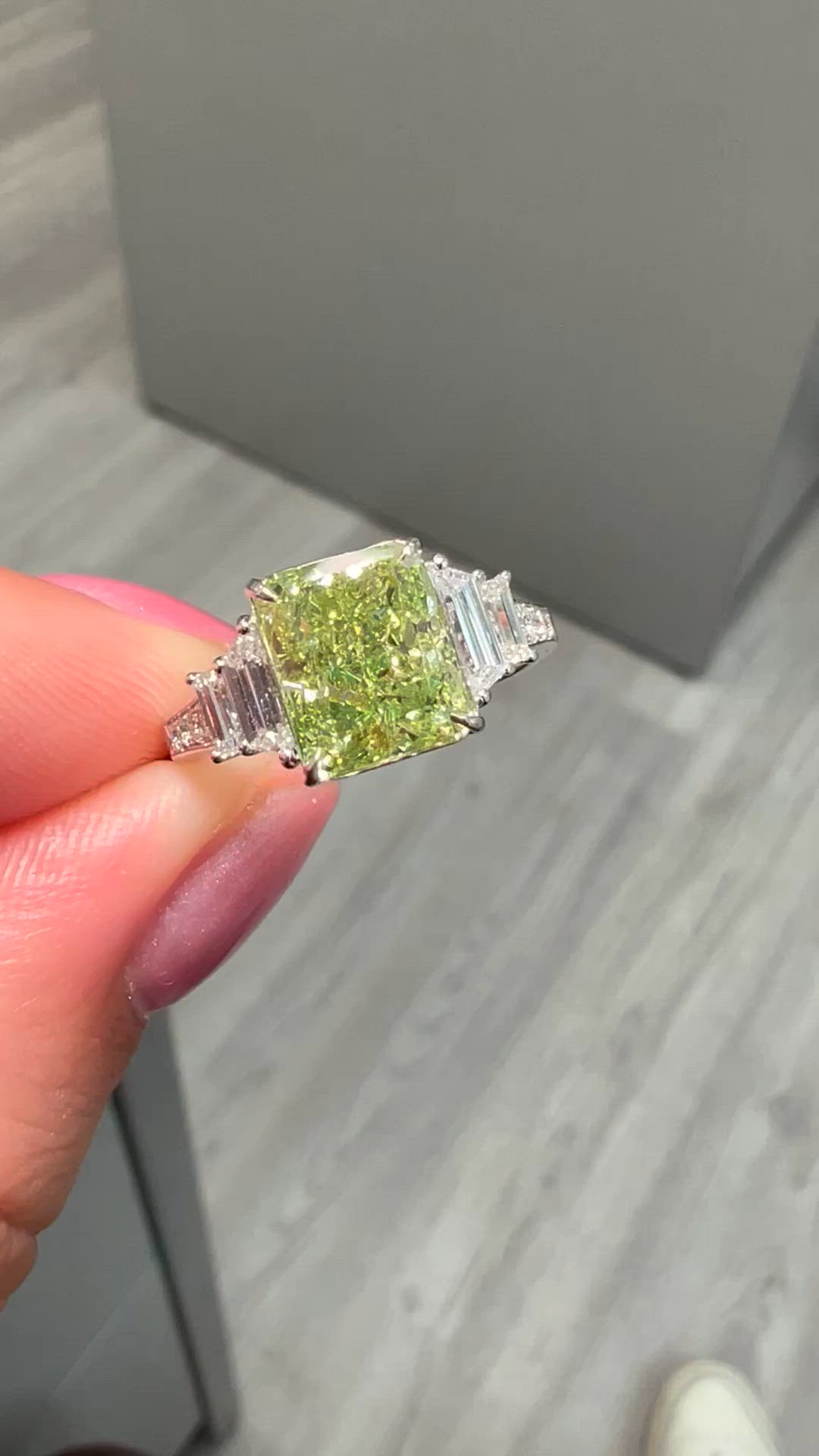 This contains: Unique green diamond engagement ring with natural green elongated radiant diamond in a multi stone design