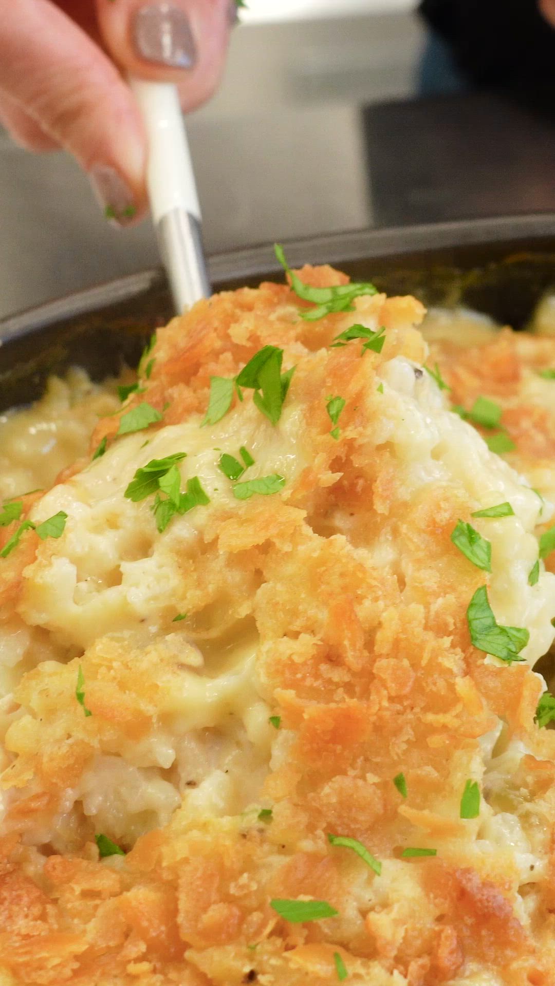 This may contain: a close up of food in a pan with a person's hand holding a spoon