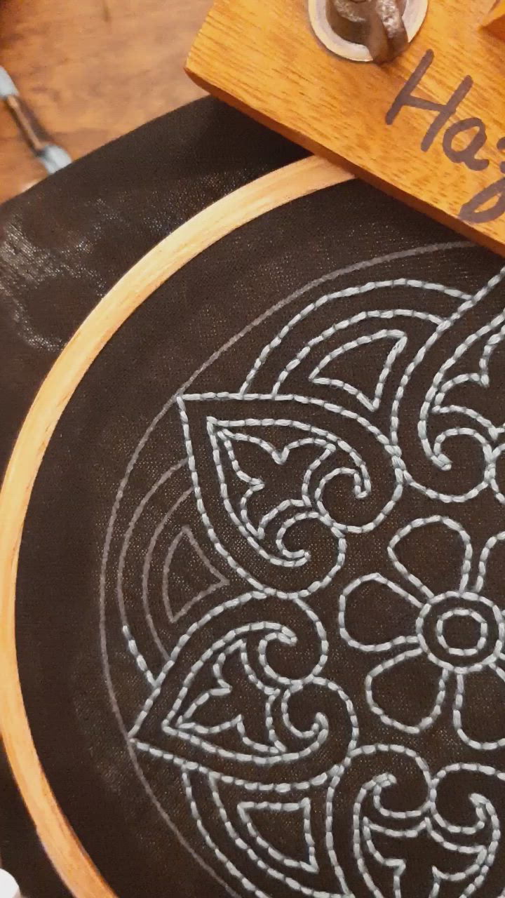 This may contain: a cross stitch pattern on a wooden hoop