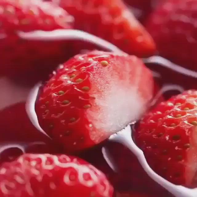 This may contain: some strawberries are laying on top of each other with water droplets all over them