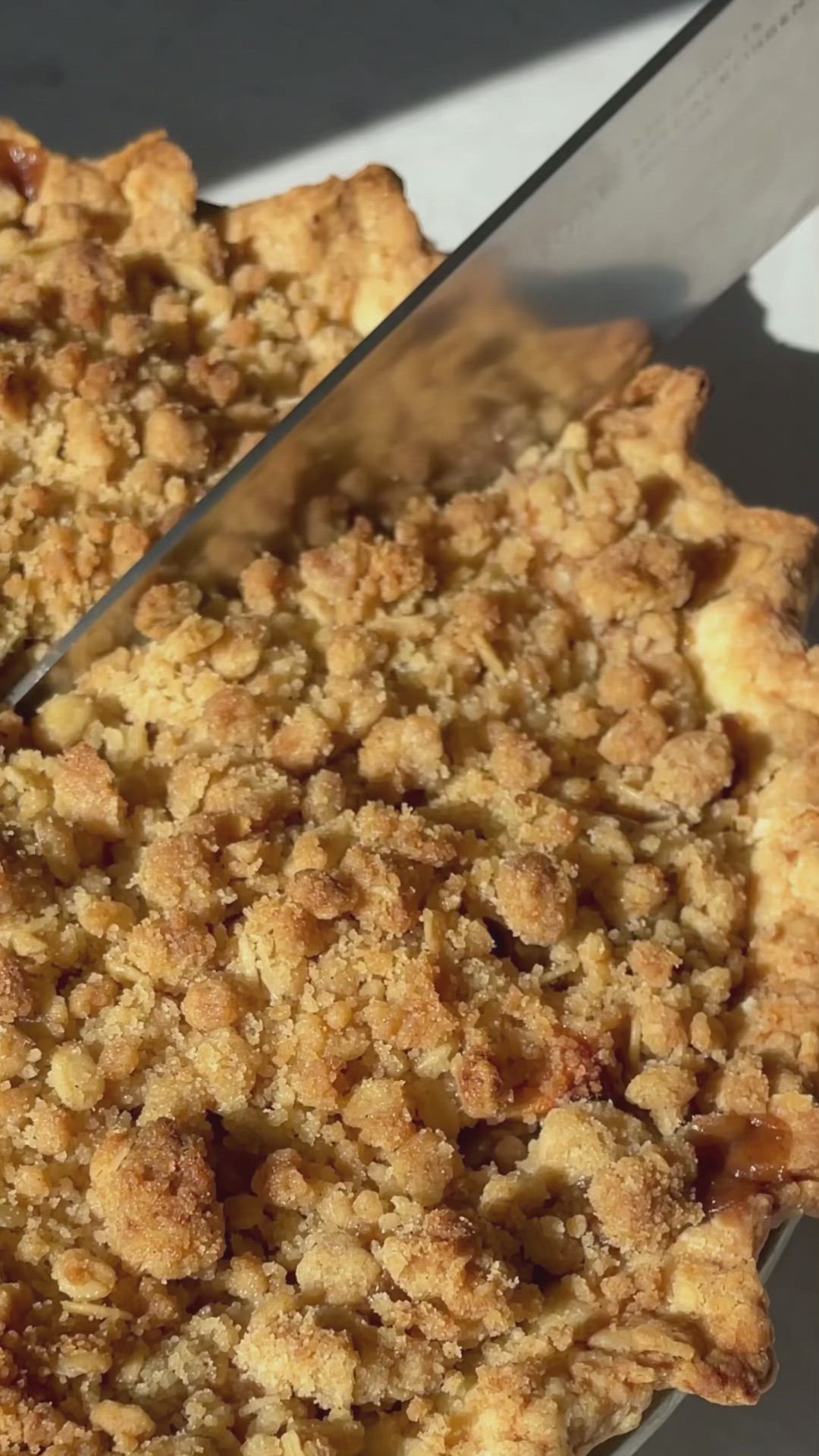 This contains: video of apple pie with Dutch crumb topping being made