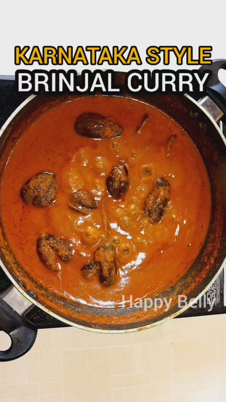 This may contain: a pan filled with food sitting on top of a stove next to a sign that says karnataka style brinjaal curry