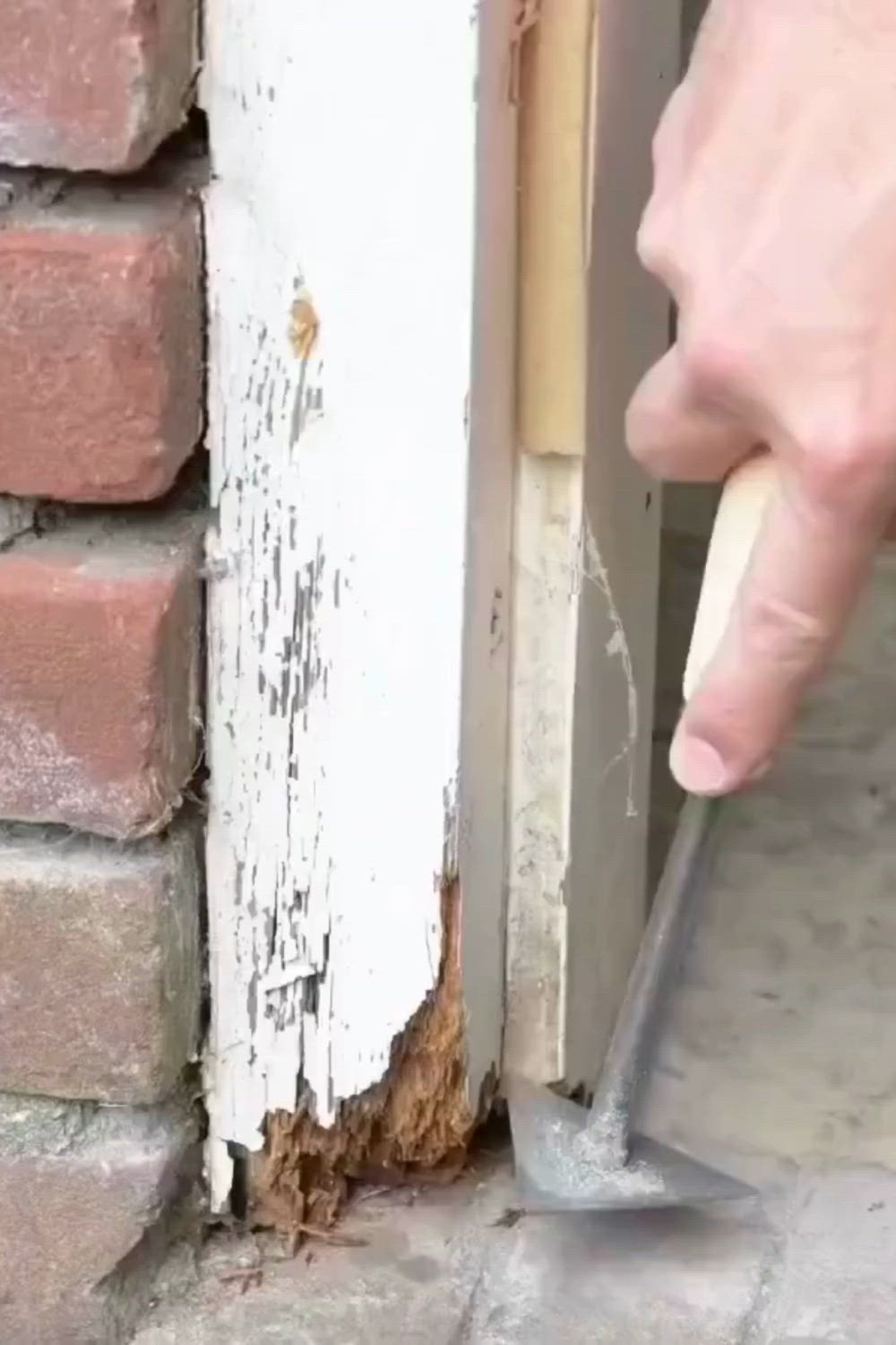 This may contain: a person is using a hammer to fix a hole in the side of a building