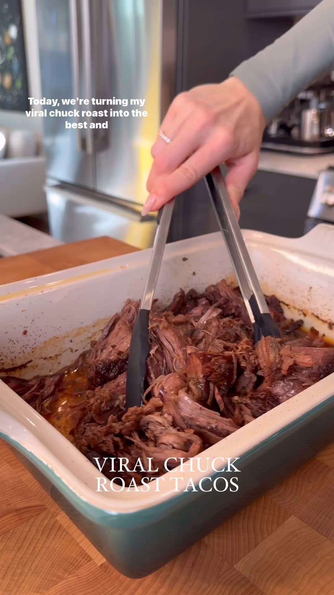 This may contain: a person is cutting meat into a casserole dish with two tongs in it