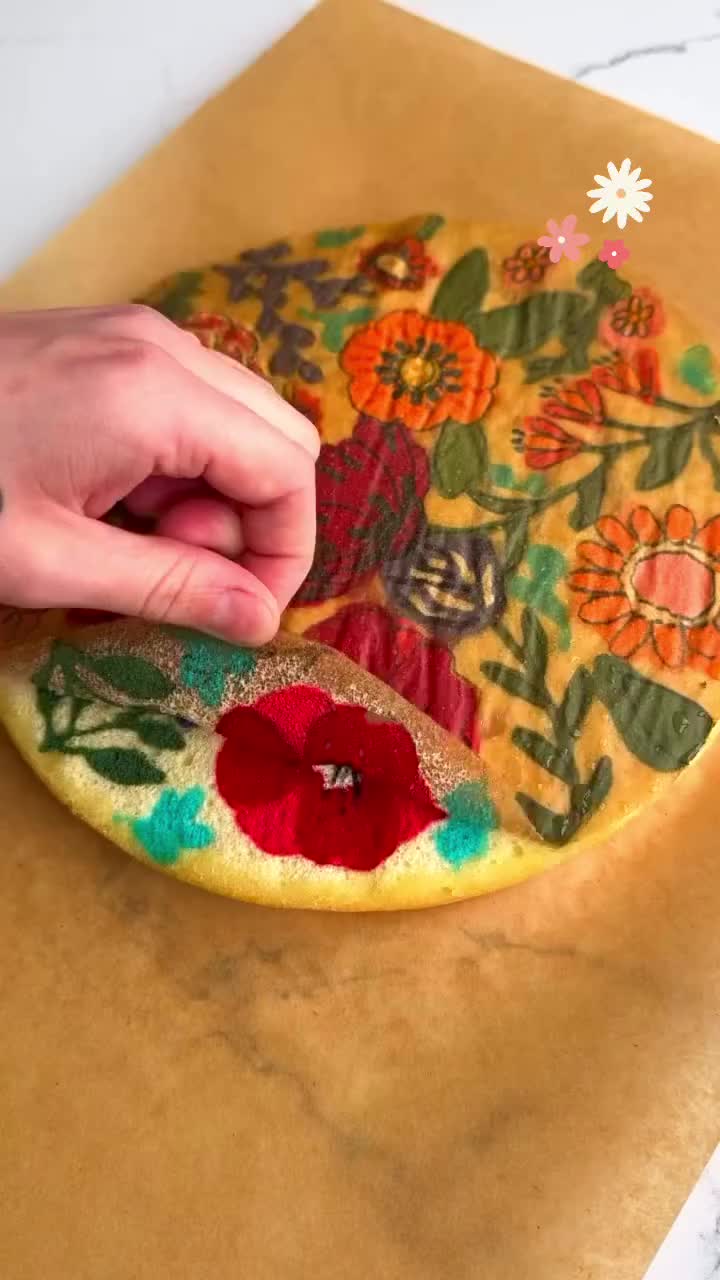 This may contain: a person is making a flower design on a piece of paper with scissors and glue