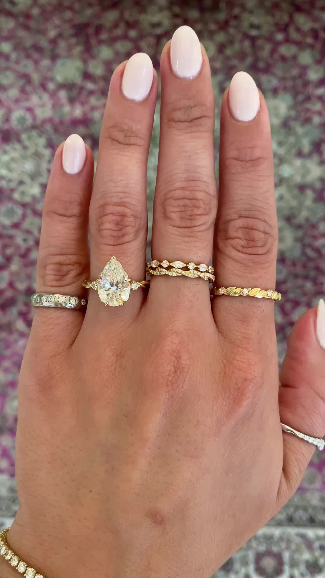 This may contain: a woman's hand with three different rings on her fingers and one is holding the other