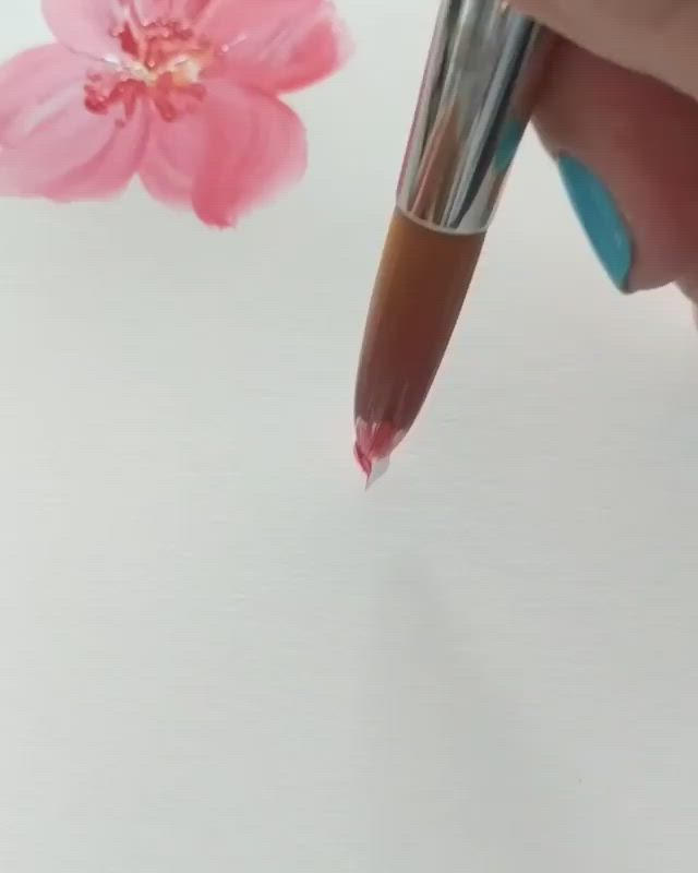 This may contain: a pink flower sitting on top of a white table next to a pen and paper