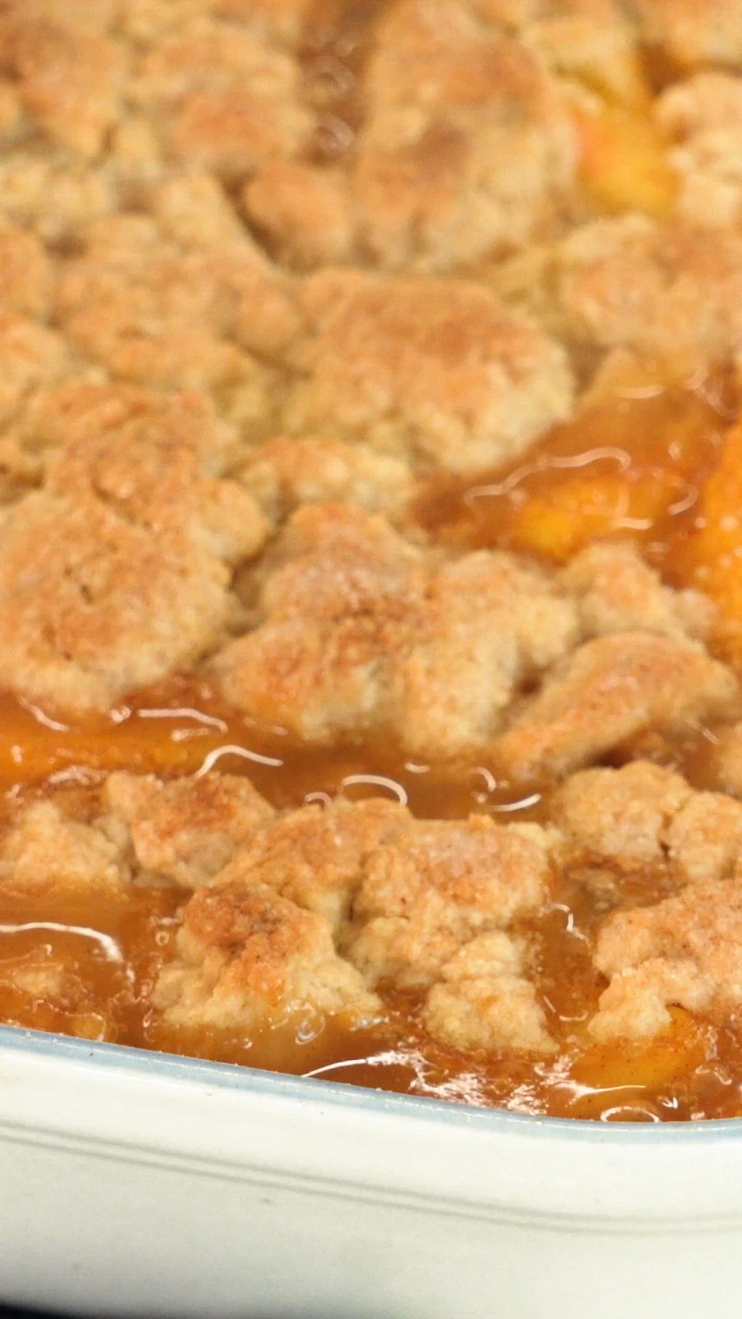 This may contain: a casserole dish filled with peach cobbler topping