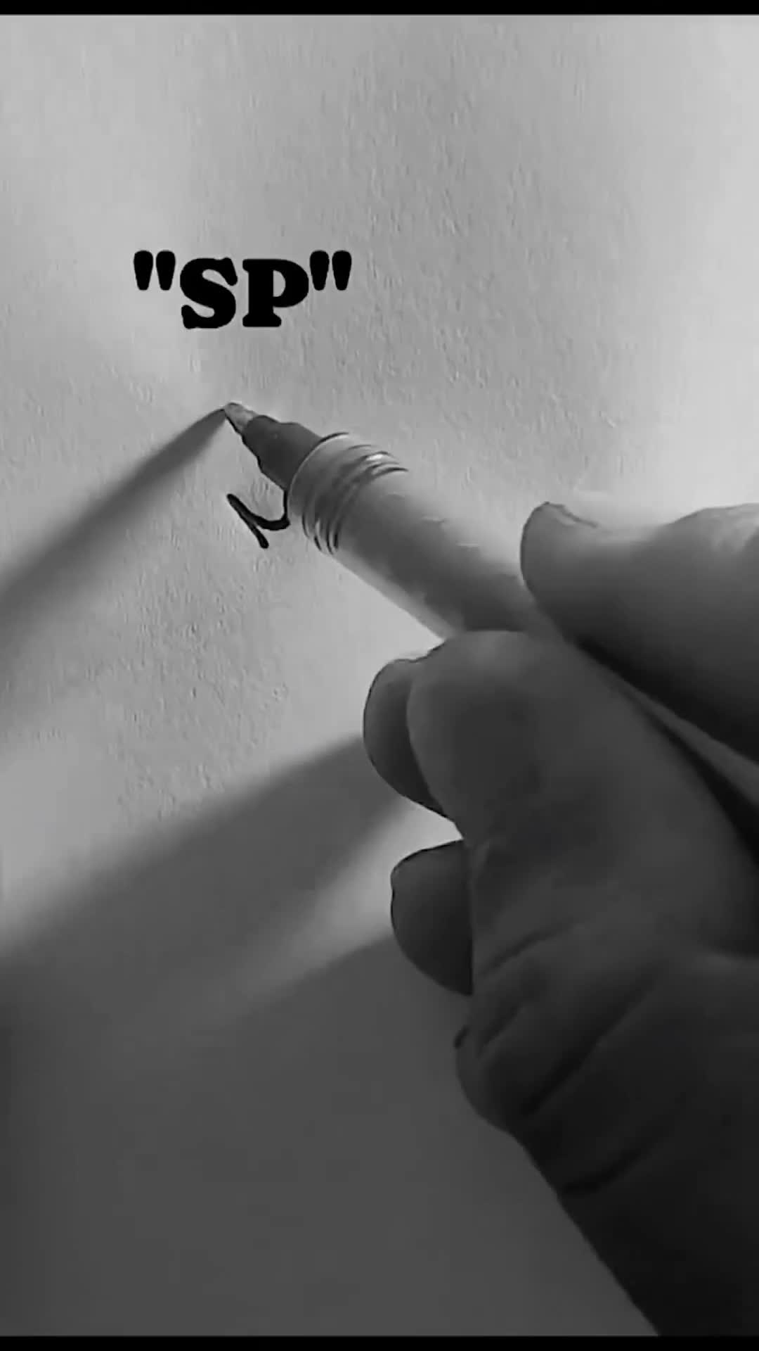 This may contain: a person holding a pen with the word sp written on it in black and white