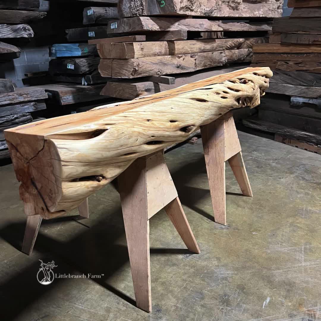 This may contain: a bench made out of wood sitting on top of a floor