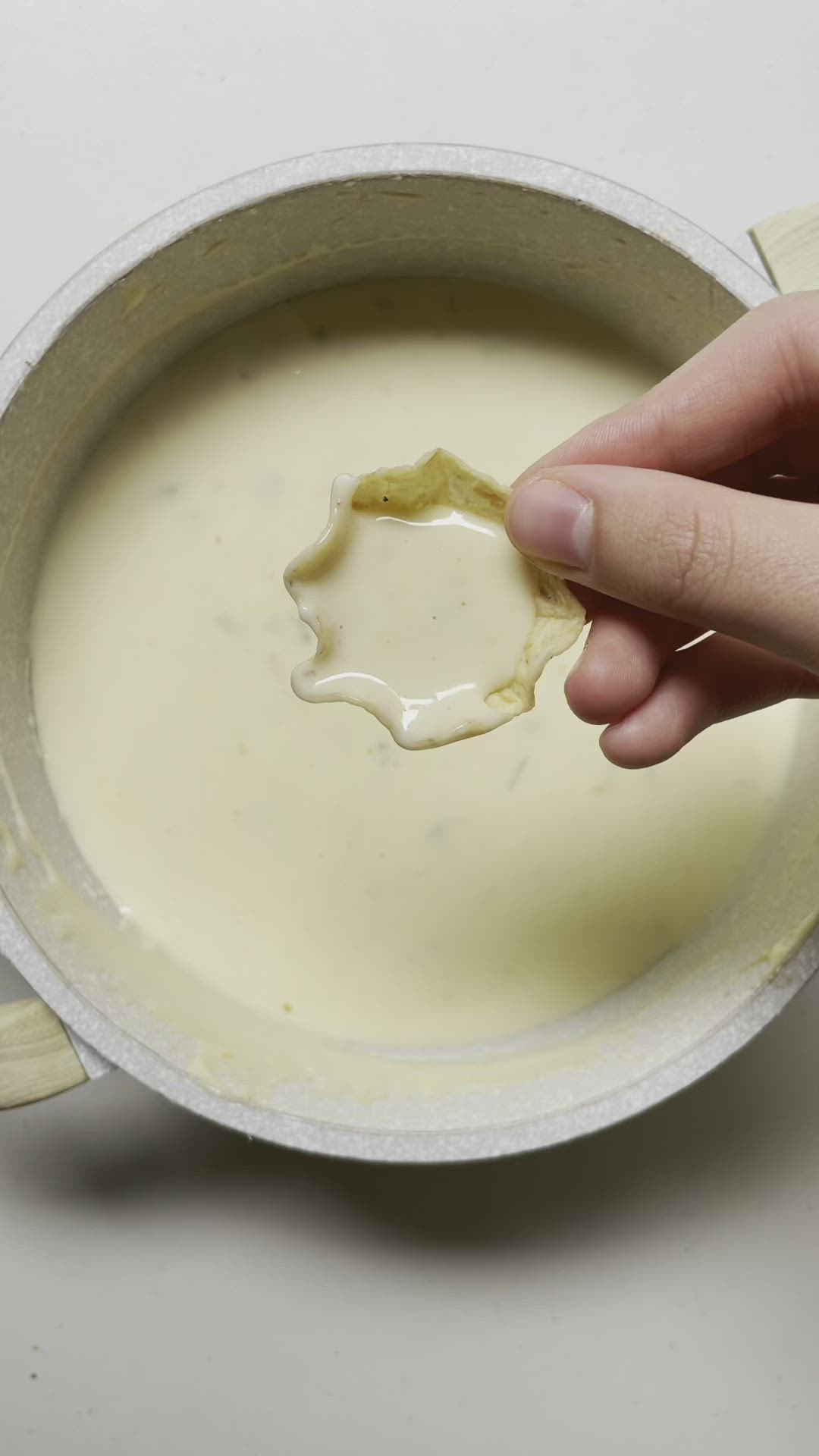 This may contain: a person dipping something in a bowl with a spoon