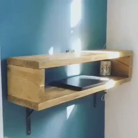 This may contain: a wooden shelf mounted to the side of a wall