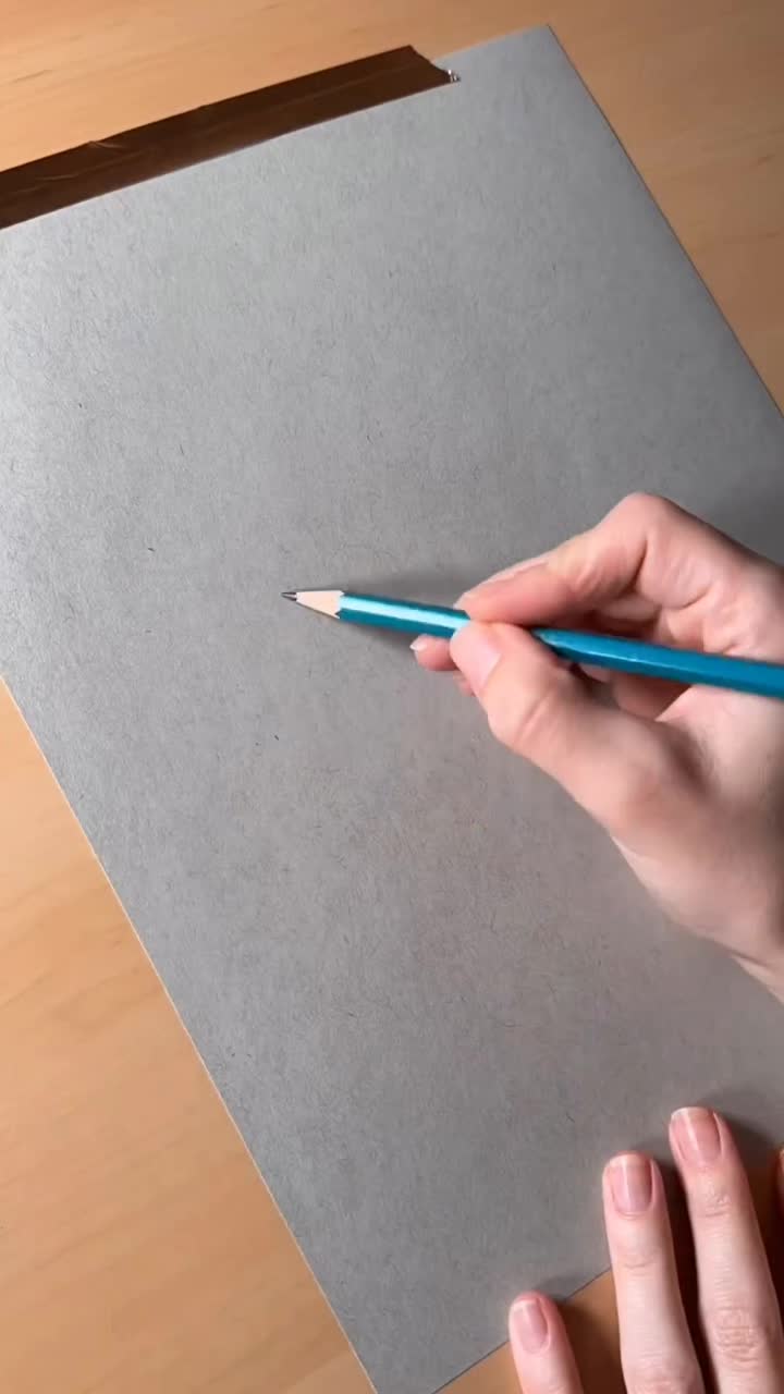 This may contain: a person is drawing on a piece of paper with a pencil and an eyeball