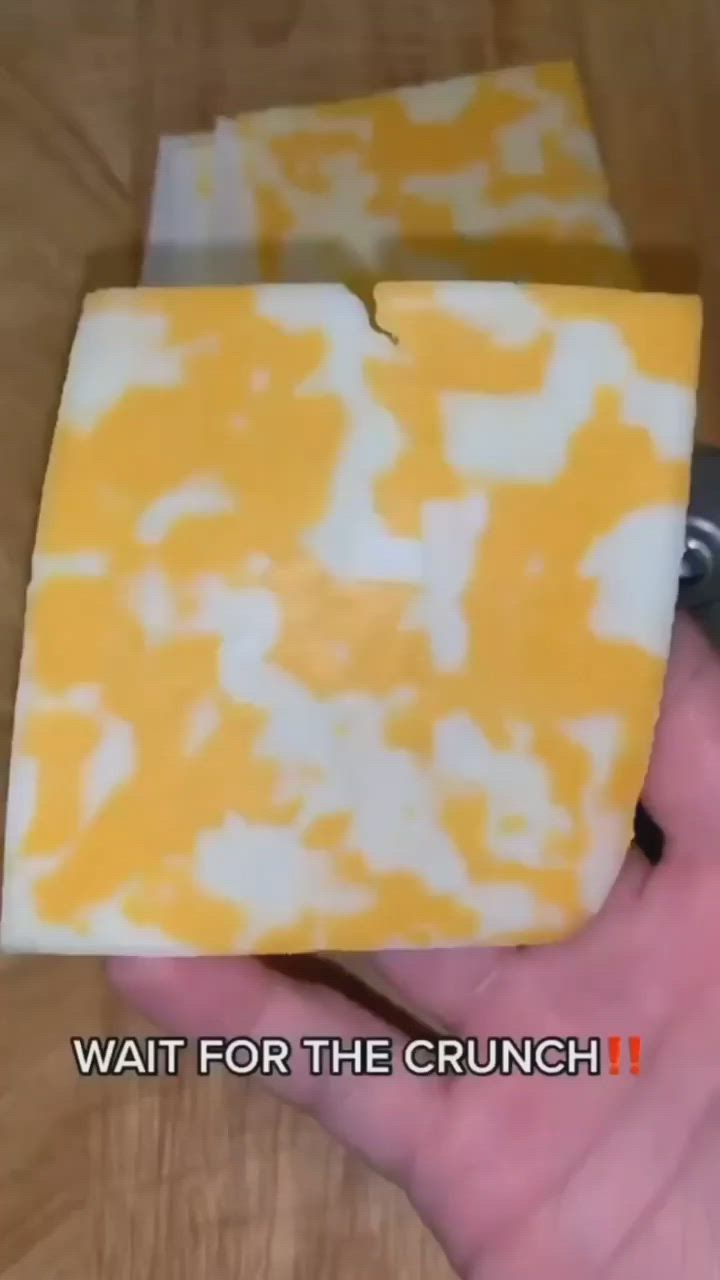 This may contain: a hand holding a piece of yellow and white soap