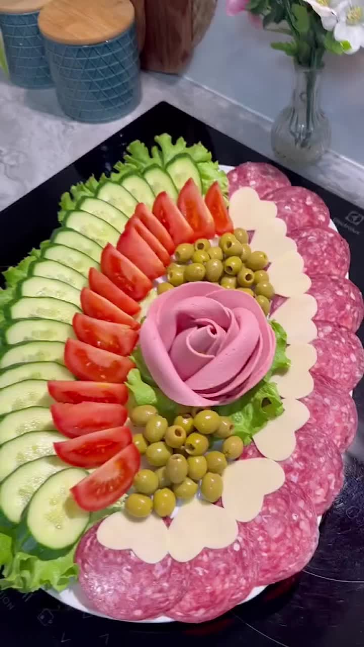 This may contain: a platter filled with meat, vegetables and sliced up fruits in the shape of a flower