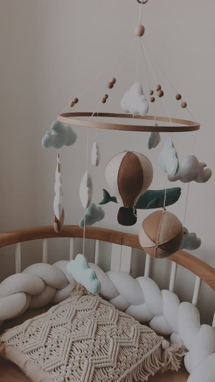 This may contain: a baby crib mobile with clouds and sea creatures hanging from it's sides