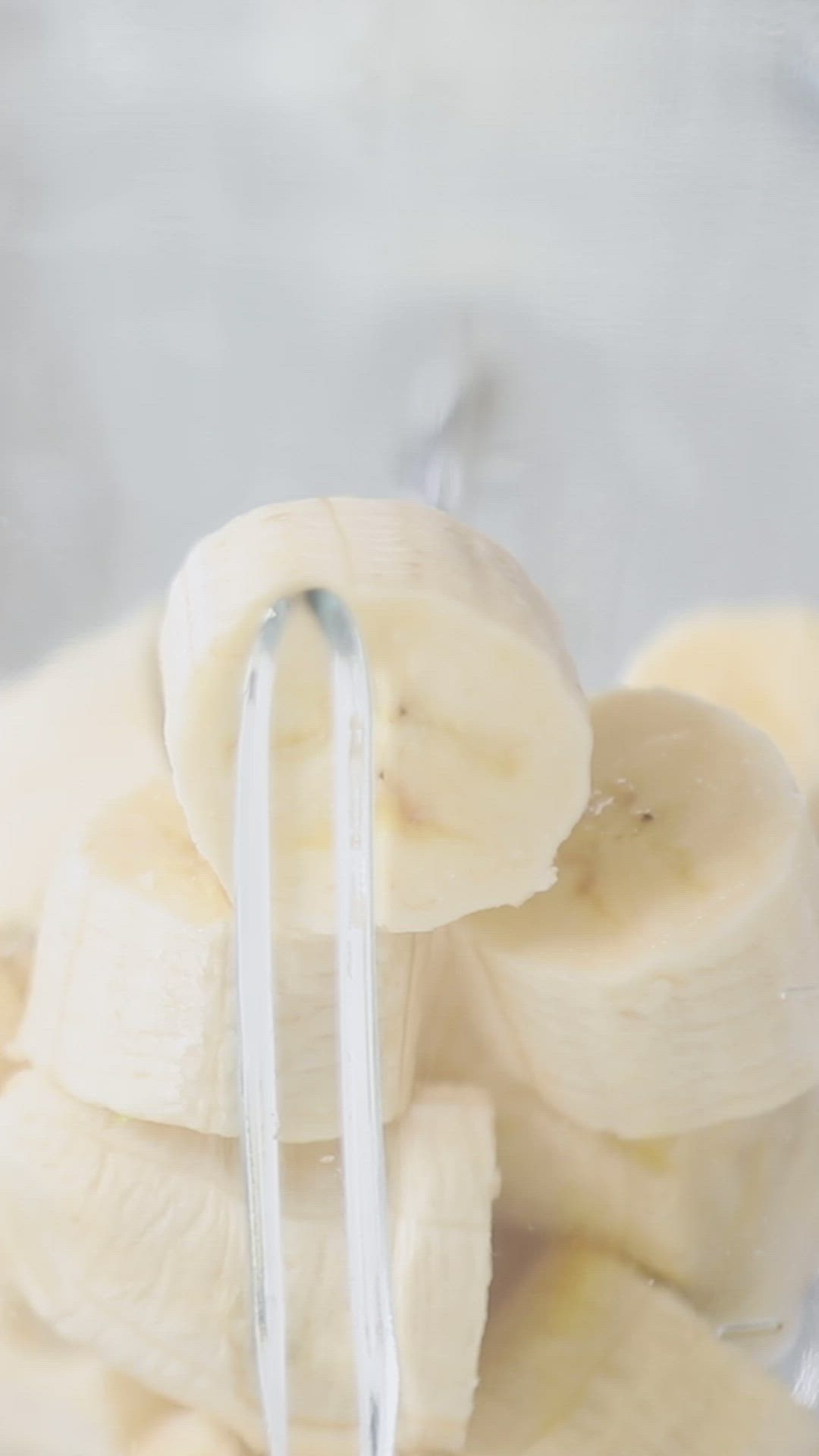 This may contain: a blender filled with bananas sitting on top of a counter