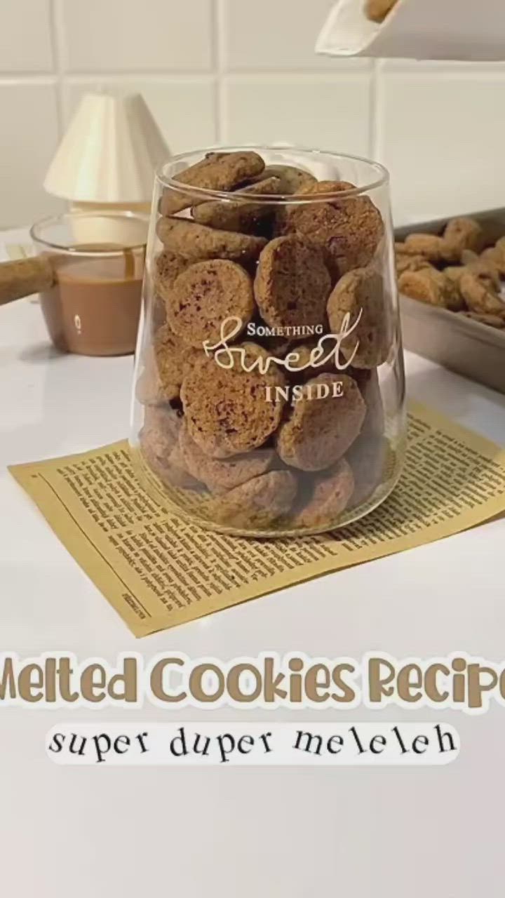 This may contain: a jar filled with cookies sitting on top of a table