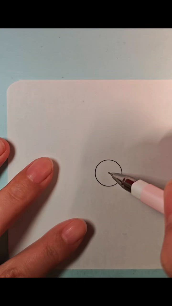 This may contain: someone is drawing something on paper with a pen and inking it in the shape of a flower