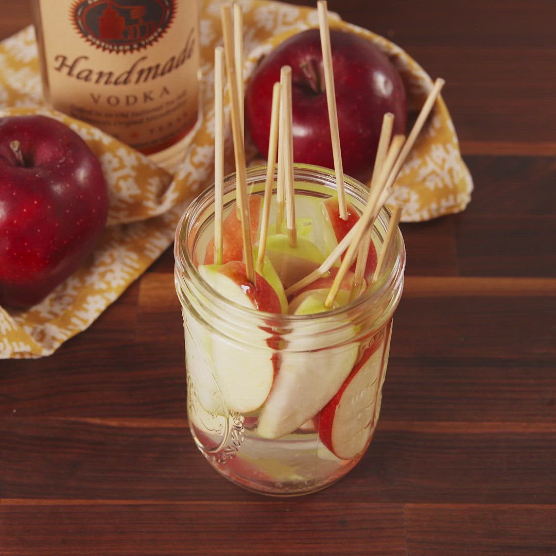 This may contain: apples, chocolate chips, and caramel sauce in bowls on a table with other ingredients